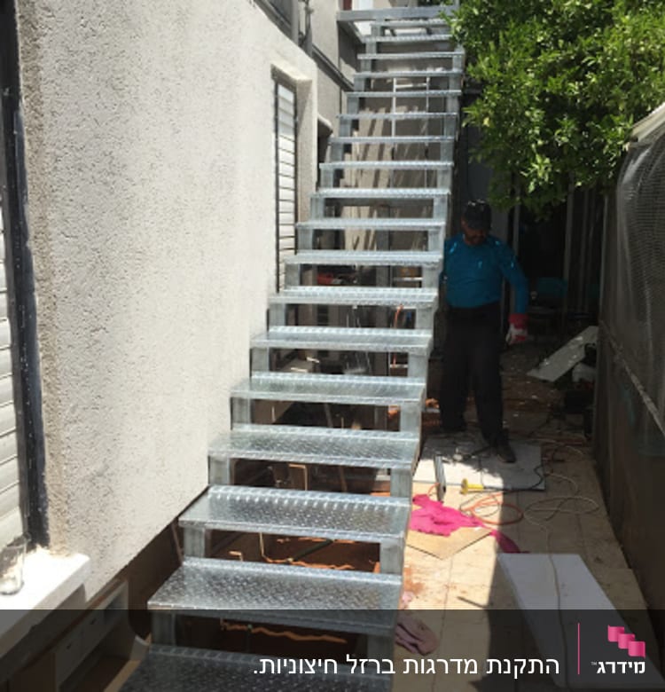 גרם מדרגות מתכת חיצוני ליד קיר בניין